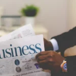 Reader holding a business newspaper on Domikyo.com