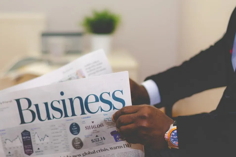 Reader holding a business newspaper on Domikyo.com