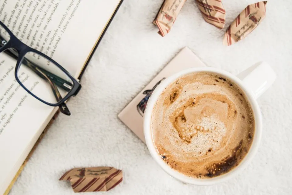 Cup of coffee beside an open book during a calm morning routine