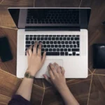 Remote worker typing on a laptop at a home desk