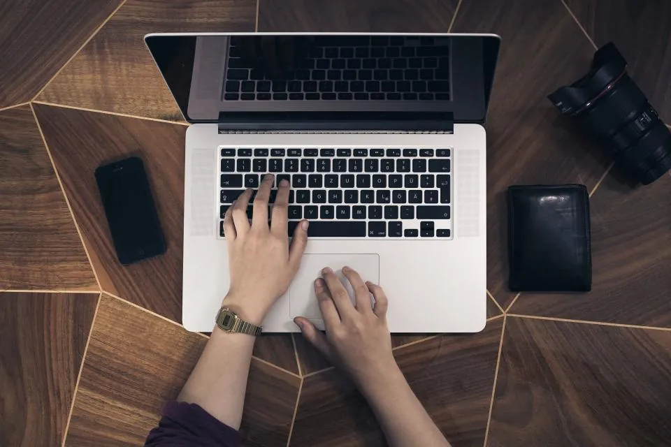Remote worker typing on a laptop at a home desk