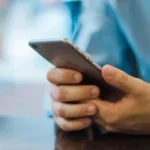 Hand holding a smartphone while reviewing security settings