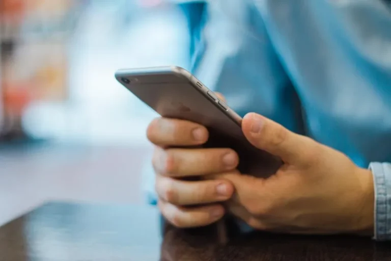 Hand holding a smartphone while reviewing security settings