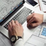 Entrepreneur sketching a small business plan on a laptop